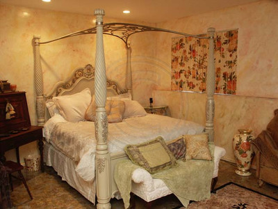 Faux finished walls depict sunrise on one side of the bedroom and sunset on the other